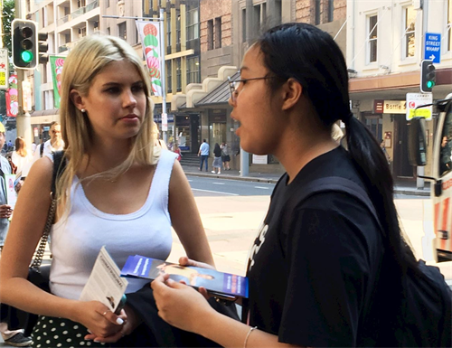 '图11:青年法轮功学员给安妮·勒梅尔(Anne Lemaire 左)讲述法轮功遭受中共迫害的真相'
