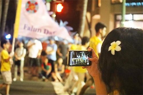 '图4:夏威夷法轮功学员的队伍路过时,观众用手机摄影留念。'