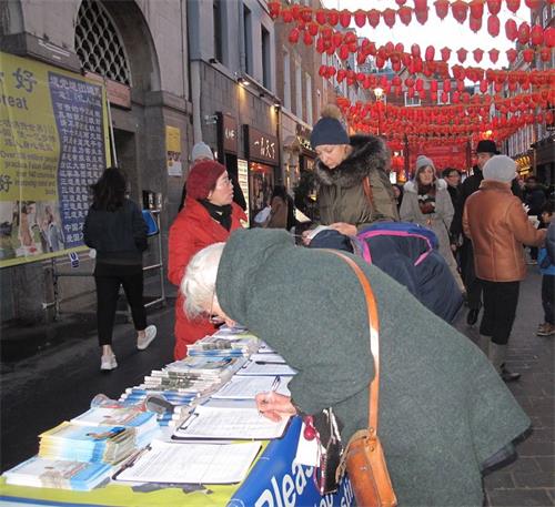 '图11:二零一九年二月十日,来自位于西班牙和法国之间的巴斯克自治区(Basque Country autonomous community)的埃斯特尔(Estelle)女士(左一)在伦敦唐人街签名支持法轮功反迫害'