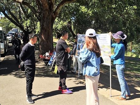 '图2:中国游客正在认真阅读横幅上的法轮功真相'