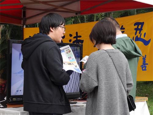 '图2:李威震(左一)正与中国大陆游客讲真相'