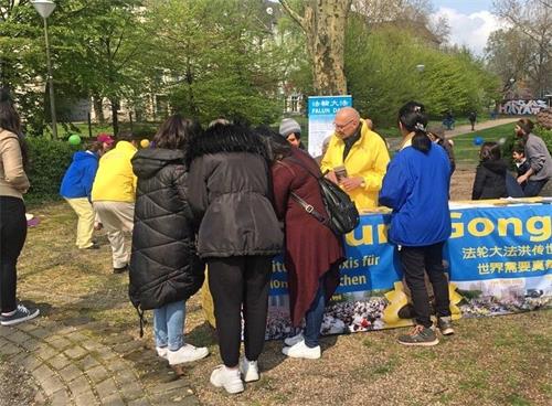 '图1:法轮功学员的信息台吸引了不少民众前来了解'
