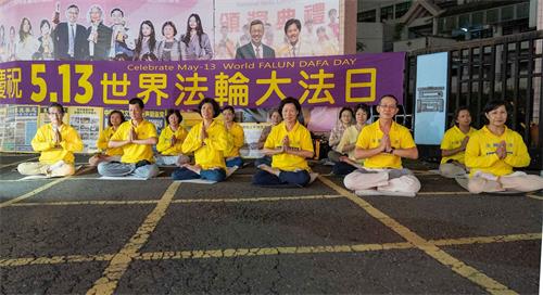 '图1:庆祝和迎接“世界法轮大法日”的到来,二零一九年五月十一日在瑞丰夜市真相点的学员双手合十:“恭祝师尊生日快乐!”。'