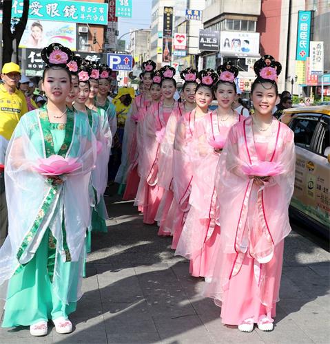 '图6:在云林县斗六市区举行五一三欢庆大游行活动,民众热烈欢迎支持,拿手机拍照,沿途有许多热情的市民高喊“法轮大法好,加油”、“法轮功,赞”。'