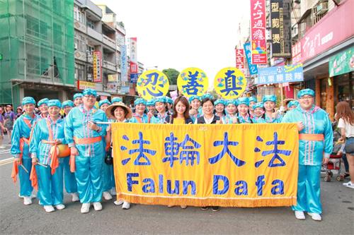 图5:头份市长罗雪珠(前中右)与法轮功学员所组成的苗栗腰鼓队,在“法轮大法”横幅及“真、善、忍”字样中,开心比“赞”合影。