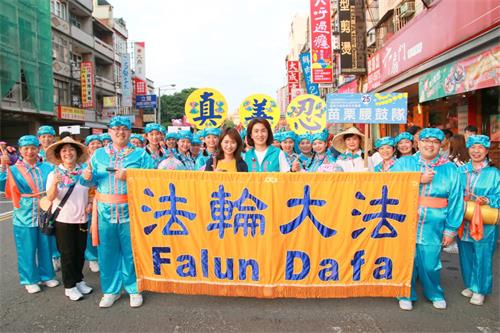 图7: 苗栗县议员张淑芬,也是头份永贞宫主委,一看到苗栗腰鼓队就喊“法轮大法好”,并开心收下印有“法轮大法好”字样的莲花吊饰,与学员开心合影。