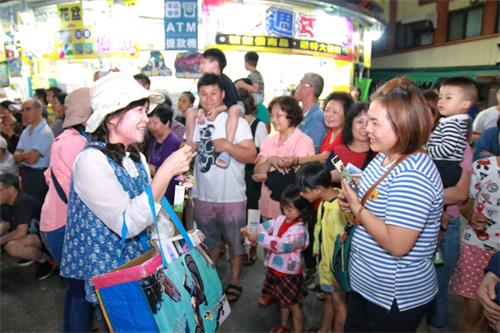 图10~11:民众开心索取及收下莲花吊饰及法轮大法相关资料,同时认真听着法轮功学员讲述真相,感受法轮大法的美好。