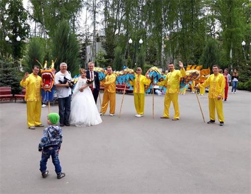 '图2:一对新人与法轮功学员合影留念'