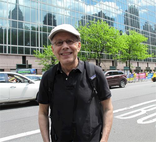 '图3:纽约人约翰·斯密斯(John Smith)驻足观看法轮功大游行'
