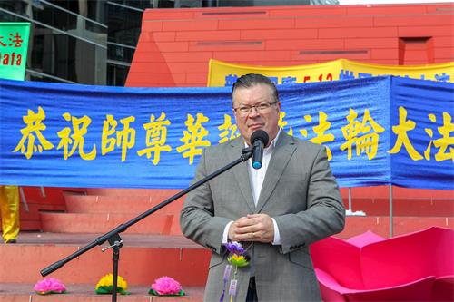'图1:二零一九年五月十一日,在墨尔本市中心女王桥广场(Queensbridge Square)举行的庆祝法轮大法洪传世界二十七周年庆典上,维州自由党上议院资深议员、反对党党鞭伯尼·菲恩(Bernie Finn MP)先生发言敬贺。'