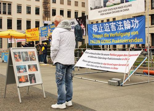 '图2:游客在阅读法轮功真相展板'