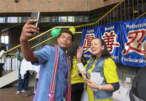 '图3:观众在法轮功的展位前留影。'