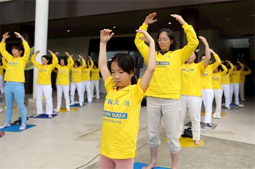 '图15~16:有不少小同修和爸爸妈妈一起参加炼功。'