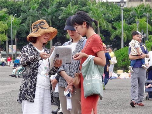 '图27:二位自由行的大陆游客与法轮功学员交谈。'