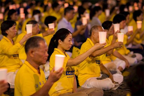 '图1~4:法轮功学员在台北市政府广场前举办反迫害二十周年烛光悼念活动。'