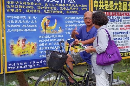 '图10~13:二零一九年七月二十日,高雄法轮功学员聚集在凤凌广场,举行法轮功反迫害二十周年集会活动。图为真相图片展、反迫害征签。不少过往民众驻足关注。'