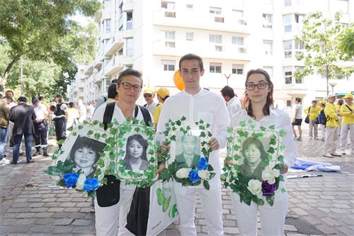 '图2:劳伦斯(右)和女儿、儿子都是开始修炼不久的新学员,他们都体验到修炼真善忍的美好,加入到揭露迫害的队伍。'
