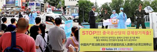 '图23:游行队伍中的揭露中共活摘法轮功学员器官的表演车及观看的中国游客和市民们。'