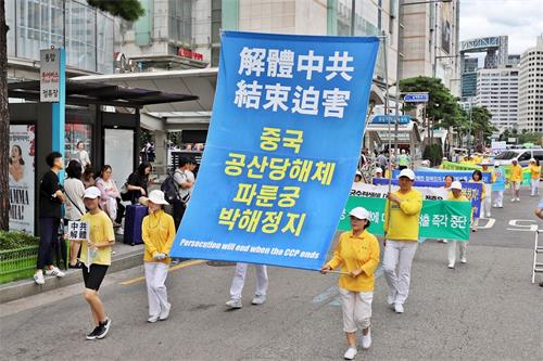 '图24~30:法轮功游行队伍走在首尔乐天百货店前。'