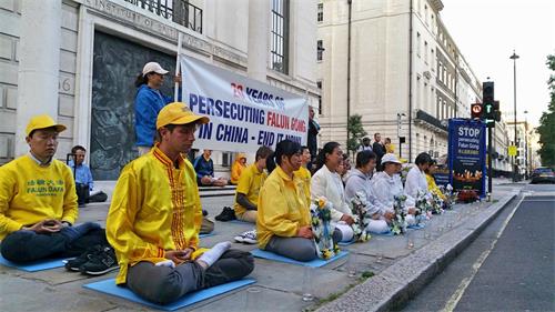 '图23~24:二零一九年七月二十日晚,英国法轮功学员在伦敦中使馆前举行烛光悼念'