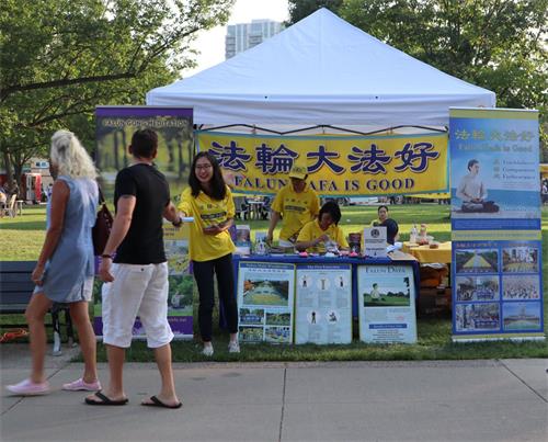 图1~2:法轮功学员在排骨节上设置展位,讲真相。