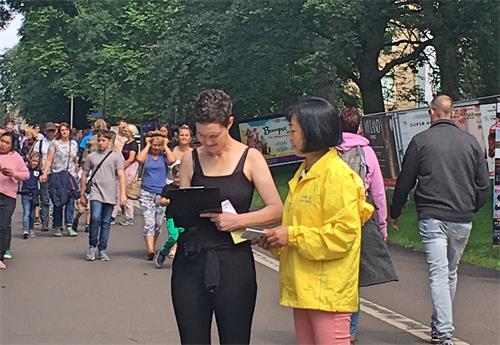 图5:这位女士(黑色上衣)了解真相后,签名声援反迫害。