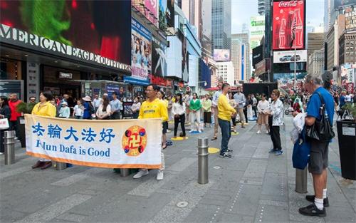 图5:游客当场跟法轮功学员学起炼功动作。