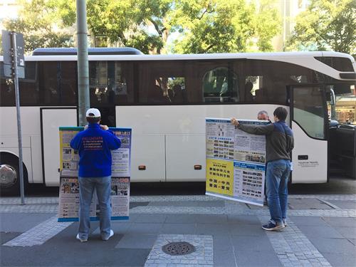 '图5:中国游客已上车,两位法轮功学员举着真相展板'