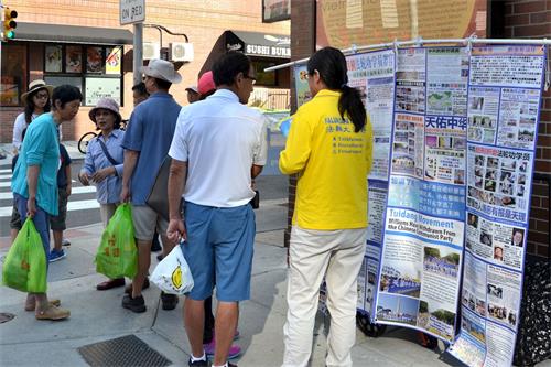 '图2:民众在观看法轮功真相展板,了解真相。'
