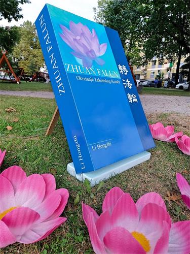 '图1:克罗地亚学员在活动中展示克罗地亚语《转法轮》书模型。'