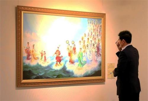 '图2:釜山市民会馆的安贤根(音译)馆长在认真欣赏画作'