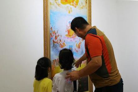 '图4:一位父亲在给孩子解说画作'