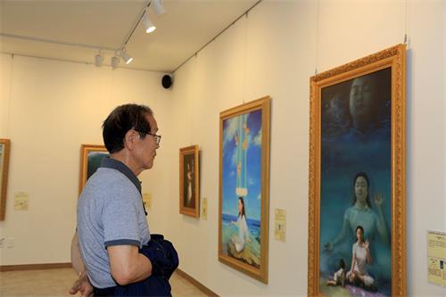 '图9:77岁的姜明德先生很高兴通过“真善忍国际美术展”了解到了修炼身心的法轮功,他对修炼产生了兴趣。'