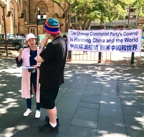 '图6:民众驻足和义工交谈了解真相'
