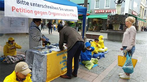 '图4:二零二零年九月二十六日,法轮功学员在沃尔姆斯(Worms)举办信息日活动,向人们介绍法轮大法的美好,中共邪恶迫害法轮功。不少过往行人驻足了解,有的了解真相后,签名支持制止迫害。'