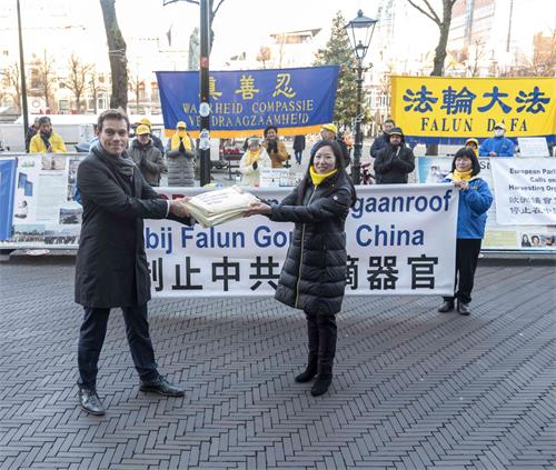图8: 荷兰议员赫尔维特先生(左)正式接收荷兰法轮大法学会发起的《制止活摘器官、制止迫害法轮功学员征签表》