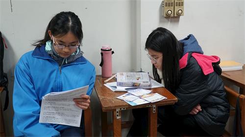 '图3:讲真相行前学员们仔细阅读真相资料。'