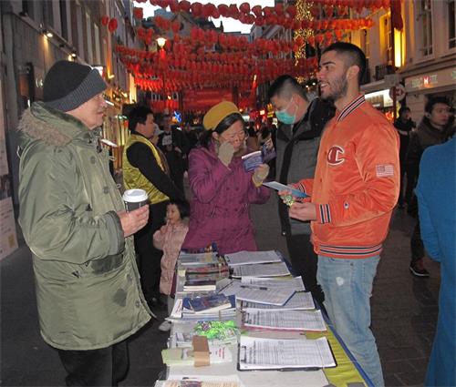 '图8：二零二零年二月一日，在伦敦唐人街，法轮功学员把«<span