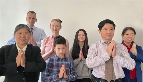 '图8:法国大法弟子唐先生(前右一)、唐太太(后右三)、两个孩子(中间)和同修们恭祝师尊生日快乐!'