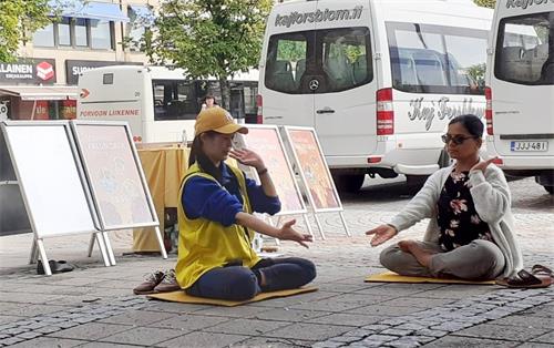 图4:尔琳当场认真学炼法轮功