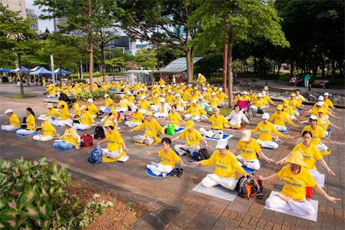'图15:台北市市府广场旁草地上还有二百多人展示法轮功五套优美功法。'