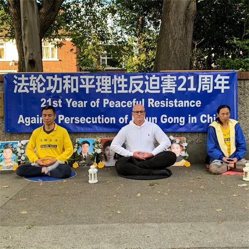 '图8~9:2020年7月20日晚,爱尔兰法轮功学员在中使馆前悼念被中共迫害致死的中国大陆同修,要求中共立即停止迫害。'