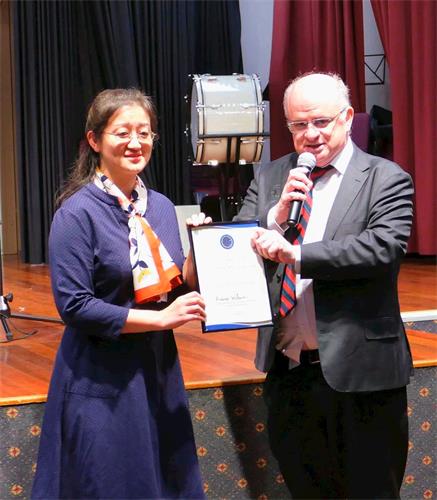 '图4:二零一九年五月三日,悉尼帕拉马塔市(City of Parramatta)市长威尔逊(右)向澳洲法轮大法学会会长赵博士(Dr Lucy Zhao)颁发了褒奖令,表彰法轮大法为当地社区所作出的贡献,并祝贺法轮大法弘传世界27周年。'