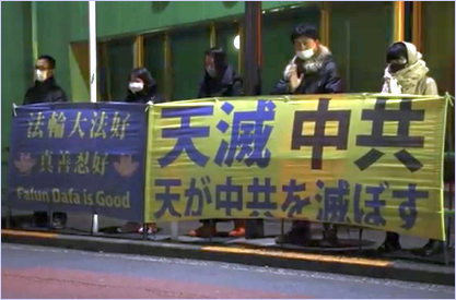 '图:在寒夜里,法轮功学员手持“法轮大法好、真善忍好” ,“天灭中共”的横幅,呼吁解体中共,停止迫害。'
