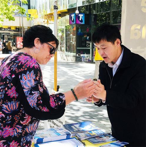 '图1~2:法轮功学员向过往路人讲述法轮功真相'