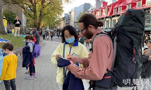 '图7:人们在呼吁反迫害的征签信上签名,表达对法轮功学员的支持'