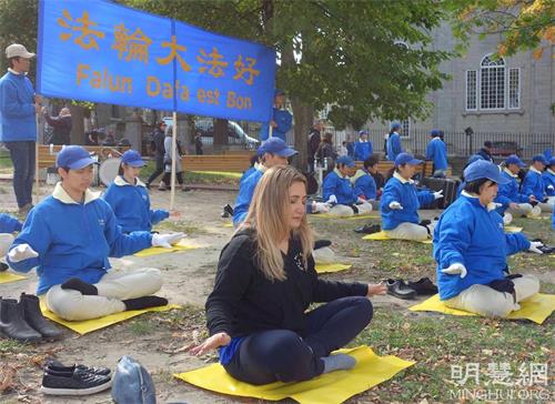 '图10:蒙特利尔学生艾里芙(Elif,中)初次次尝试法轮功功法,感觉到很强的能量。'