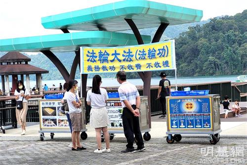 '图1:日月潭伊达劭景点法轮功真相点,民众正阅读真相展板。'