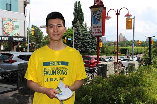 '图2:越南留学生艾文‧武(Evan Vu)在尼加拉瀑布向民众弘法。'