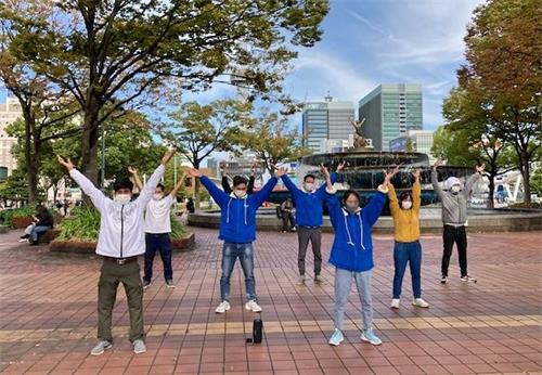 '图1~2:二零二一年十月二十四日(星期日),日本中部地区法轮功学员在名古屋市(Nagoya-City)最繁华地段——荣(Sakae)的喷水附近集体炼功,向过往行人传播法轮功的真相。'